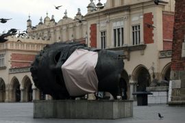 A sculpture Eros Bendato with a mock mask is seen on the main square during the coronavirus disease (COVID-19) lockdown in Krakow, Poland, on March 23, 2020 [Jakub Wlodek/Agencja Gazeta via Reuters]