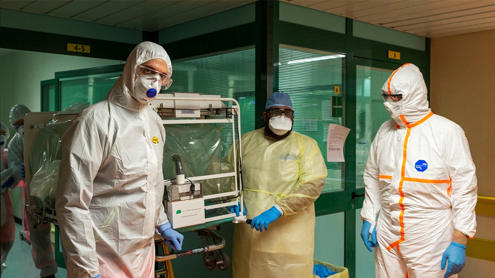 Medical workers in protective suits transfer a coronavirus patient from the intensive care unit of the Gemelli Hospital to the Columbus Covid Hospital, which has been assigned as one of the new corona