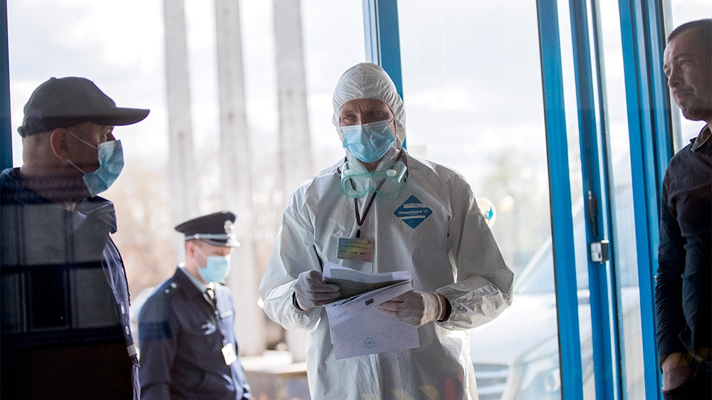 epa08294434 Customs officers wear protective masks as they control the  cars of passengers arriving at the Leuseni Custom, Moldova, 14 March 2020. Moldova closes some border crossings with Romania aft
