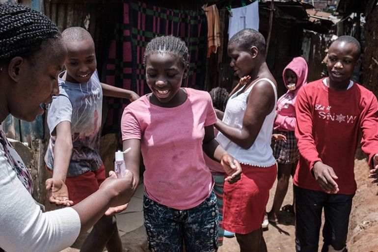 A volunteer of local NGO Shining Hope for Communities (SHOFCO) provide hand disinfectant to people as a preventive measure for the COVID-19 coronavirus at the Kibera slum in Nairobi, on March 18, 2020