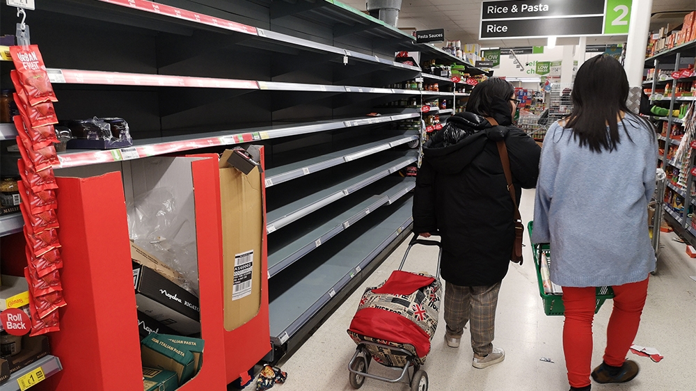 Consumers shop in near empty aisles of a supermarket in London on March 13, 2020, as consumers worry about product shortages, leading to the stockpiling of household products due to the outbreak of th