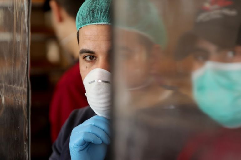 Palestinians, wearing masks as a preventive measure against the coronavirus disease, work in a bakery in Gaza City