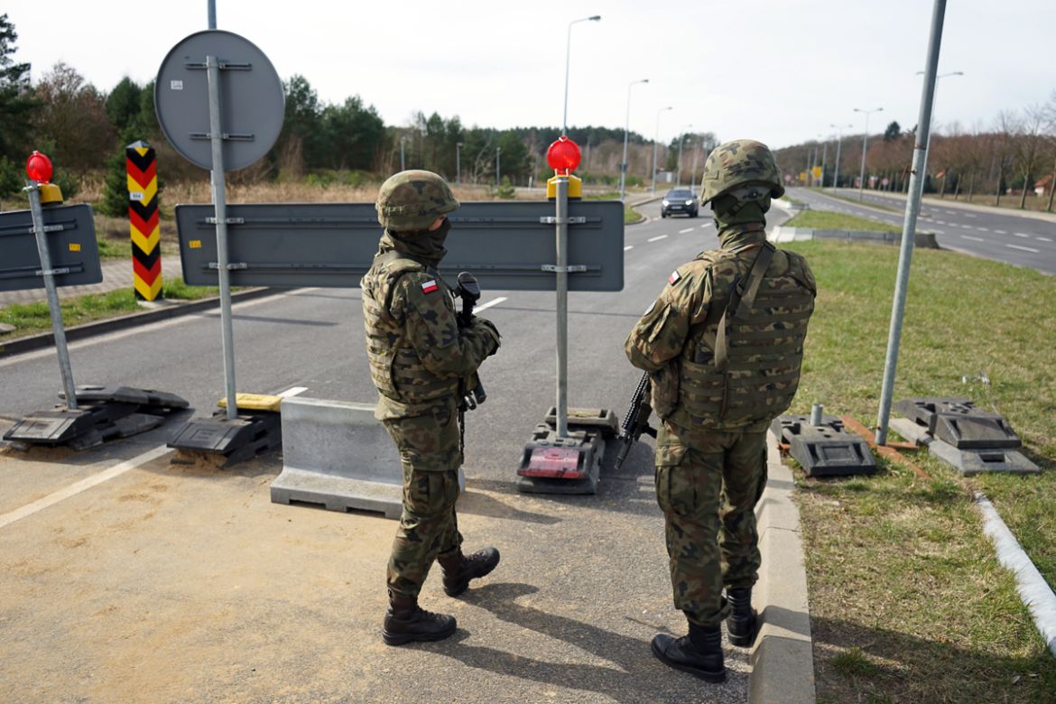 epa08303814 Soldiers of the 12th Mechanized Brigade with police help seal the border with Germany in Lubieszyn in the West Pomeranian Voivodeship, Poland 18 March 2020. Due to the threat of spreading