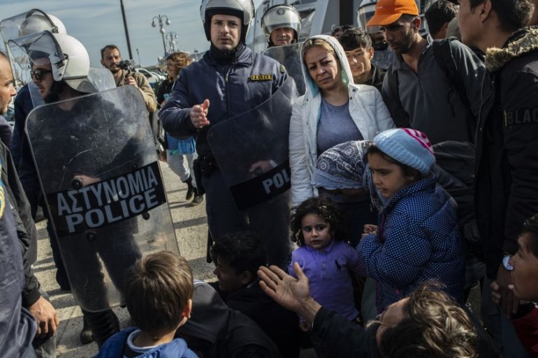 Riots police push back migrants outside the port of Lesbos