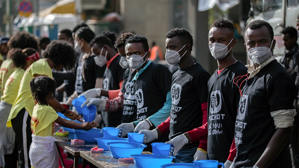 Volunteers stand ready to provide soap and water for participants to wash their hands against the new coronavirus at a women's 5km fun run in the capital Addis Ababa, Ethiopia Sunday, March 15, 2020. 