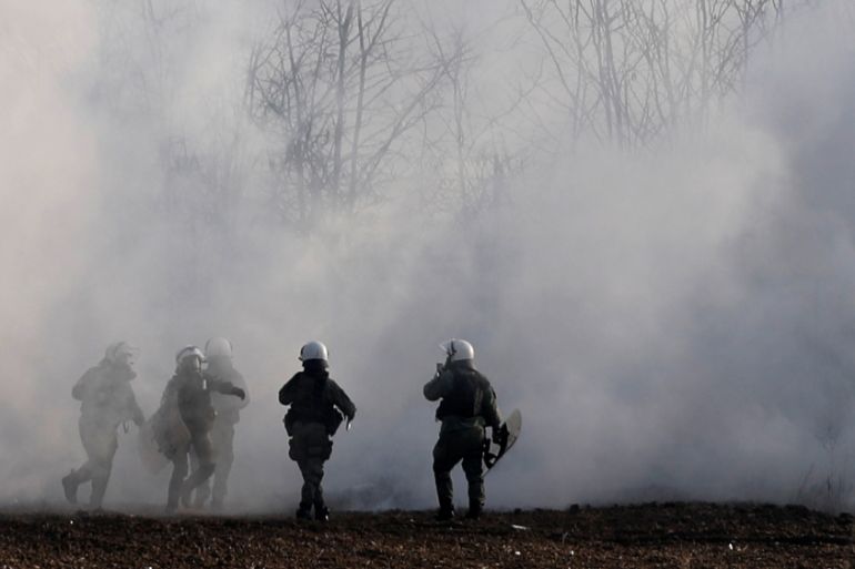 Greek riot police officers walk amid clouds of tear gas near Turkey''s Pazarkule border crossing, in Kastanies