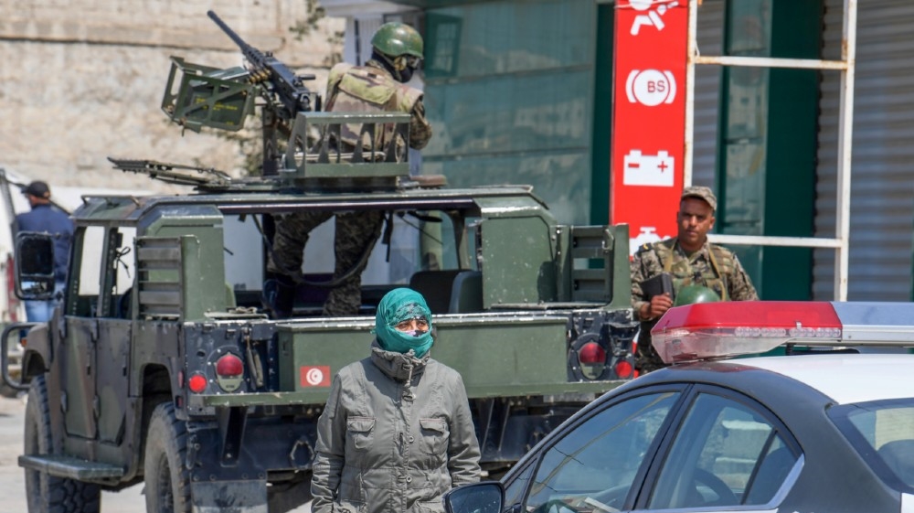 Tunisian soldiers stand guard next to the headquarters of Mnihla delegation in Ariana Governorate during a demonstration against the general confinement, on March 30, 2020