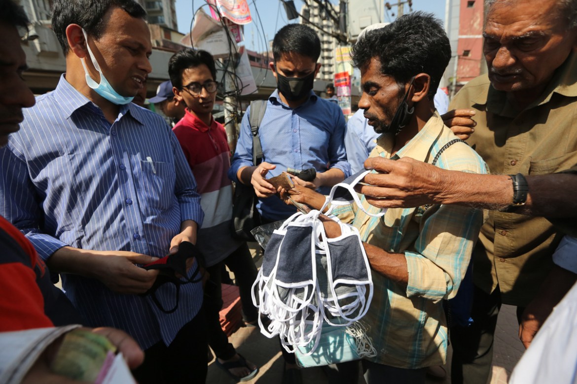 People buy face masks on a street in Dhaka. Mahmud Hossain Opu/Al Jazeera