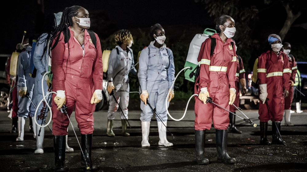 Members of a privately-funded NGO working with county officials wearing protective carry their gear during the dusk-to-dawn curfew imposed by the Kenyan Government [Luis Tato/AFP]