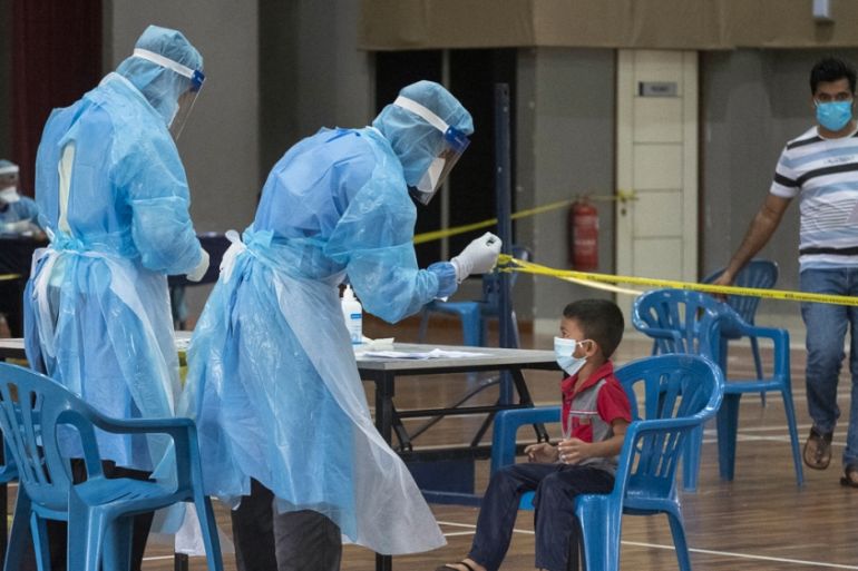 A child is tested for Covid-19 at a temporary testing facility set up by the Malaysian Ministry of Health in a community centre at the outskirts of Kuala Lumpur. [Alexandra Radu/Al Jazeera]