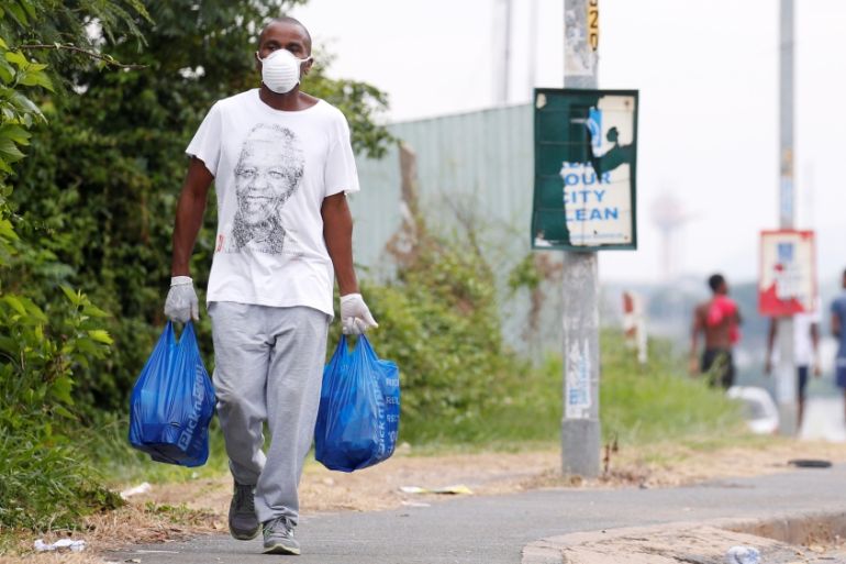 A man carries home groceries during a nationwide 21 day lockdown in an attempt to contain the coronavirus disease (COVID-19) outbreak in Umlazi township near Durban