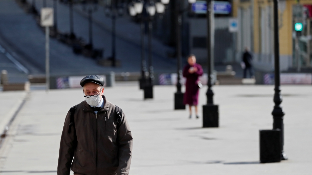 A man wearing a protective face mask walks along the street in Moscow
