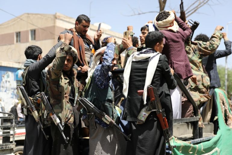 Armed Houthi followers ride on the back of a truck outside a hospital in Sanaa