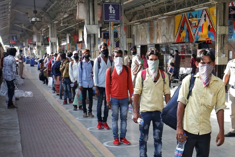 Migrant workers, who were stranded in the western state of Gujarat due to a lockdown imposed by the government to prevent the spread of coronavirus disease (COVID-19), maintain social distance as they