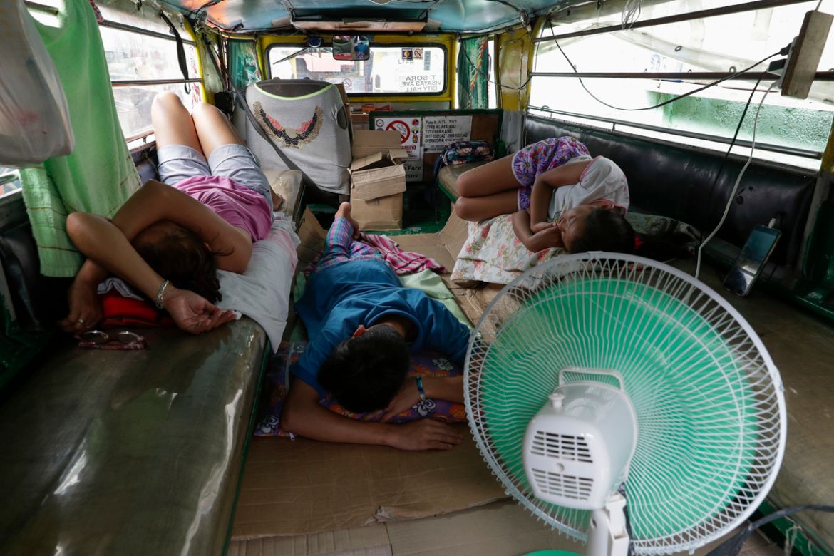 The Recio family sleeps inside their passenger jeepney at a terminal which have been home for them on Wednesday, June 17, 2020 in Quezon city, Philippines. About 35 jeepney drivers were forced to stay