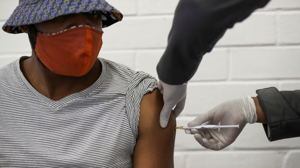 A volunteer receives an injection from a medical worker during the country's first human clinical trial for a potential vaccine against the novel coronavirus, at Baragwanath Hospital in Soweto, South 
