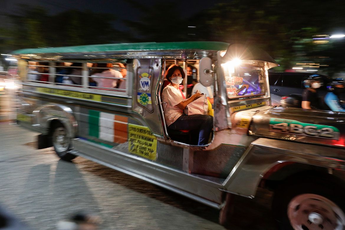 A woman wears a protective mask as she rides a passenger jeepney in Manila, Philippines on Tuesday, March 10, 2020. For most people, the new coronavirus causes only mild or moderate symptoms, such as
