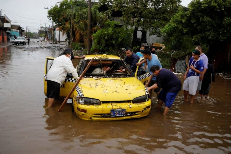 Neighbors try to move a taxi dragged by the water during floods caused by Tropical Storm Amanda at El Modelo neighborhood, in San Salvador, El Salvador May 31, 2020. REUTERS/Jose Cabezas