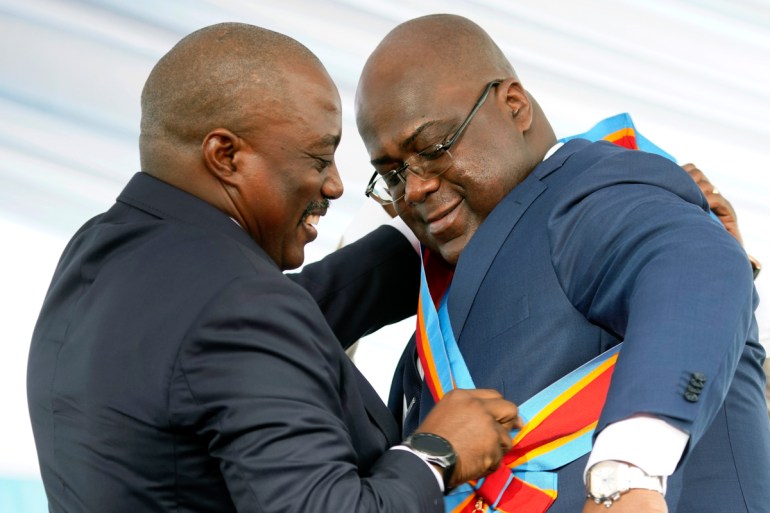 Congolese President Felix Tshisekedi receives the presidential sash from outgoing president Joseph Kabila after being sworn in in Kinshasa, Democratic Republic of the Congo, Thursday Jan. 24, 2019.