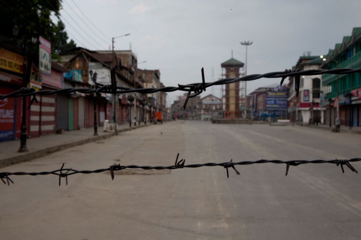 In this Tuesday, Aug. 6, 2019 photo, a deserted street is seen through a barbwire set up as blockade during curfew in Srinagar, Indian controlled Kashmir, Wednesday, Aug. 7, 2019. Authorities in Hindu