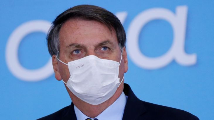 Brazil''s President Jair Bolsonaro wearing protective mask looks on during the launching ceremony of the Plano Safra 2020/2021, an action plan for the agricultural sector, in Brasilia, Brazil, June