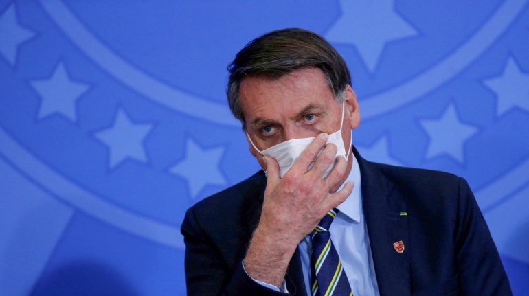 Brazil''s President Jair Bolsonaro adjusts his protective face mask during the inauguration ceremony of the new Communications Minister Fabio Faria (not pictured) at the Planalto Palace, in Brasilia, B