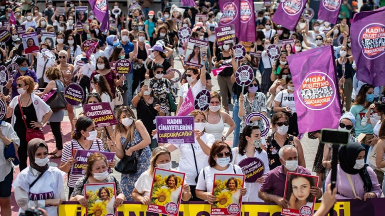 Demonstrators, wearing protective face masks, hold placards and portraits of women, during a protest called by KCDP (We Will Stop Femicides Platform - Kadin Cinayetlerini Durduracagiz Platformu) and W