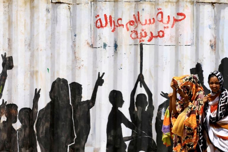 Civilians walk past graffiti reading in Arabic "Freedom, Peace, Justice and Civilian" in the Burri district of Khartoum, Khartoum, Sudan, July 10, 2019. REUTERS/Mohamed Nureldin Abdallah