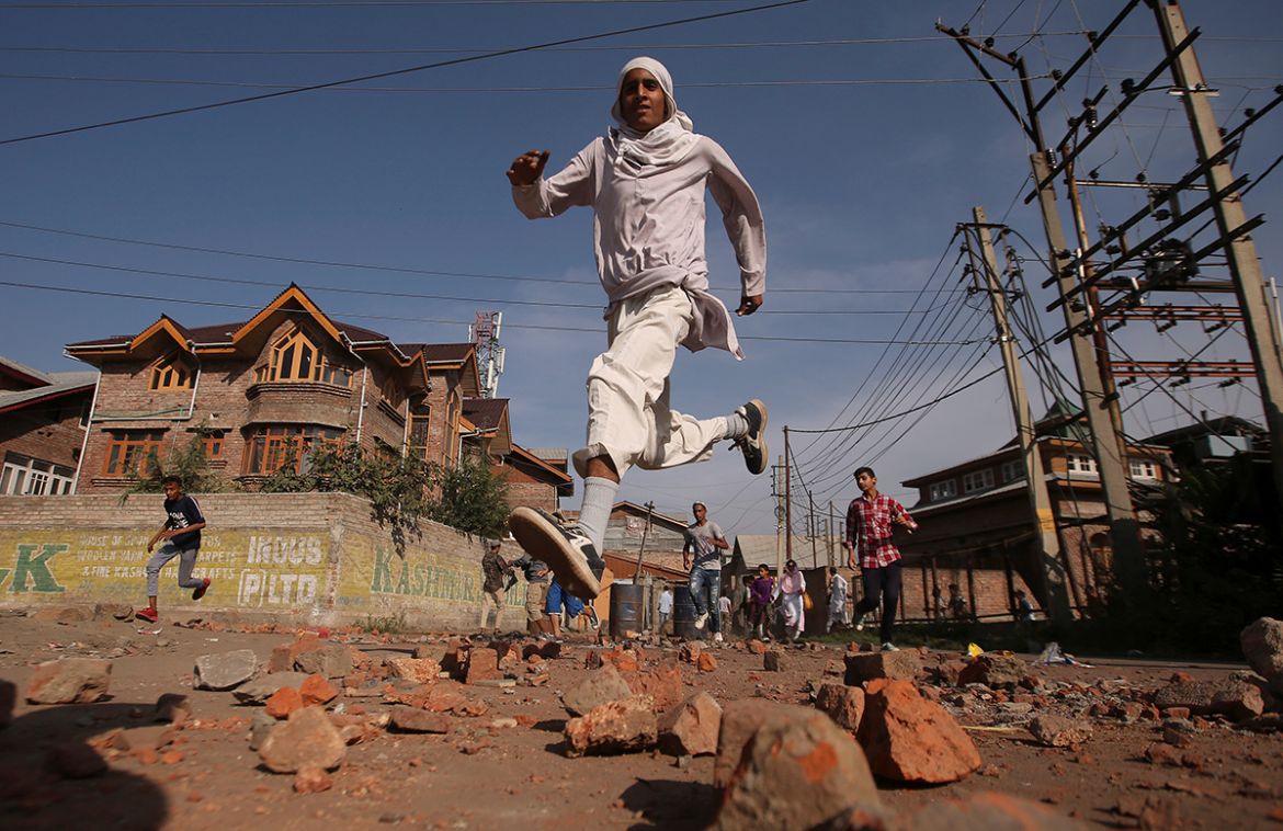 Kashmiris run for cover as Indian security forces (not pictured) fire teargas shells during clashes, after scrapping of the special constitutional status for Kashmir by the Indian government, in Srina