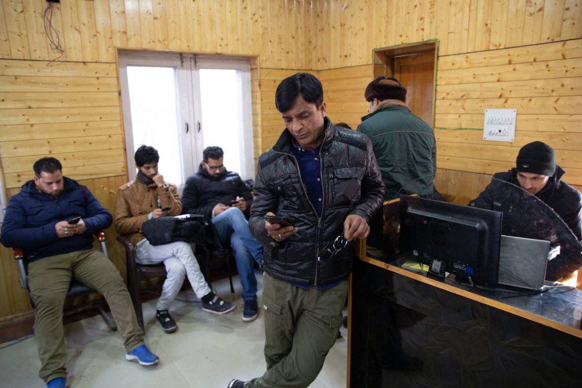 FILE - In this Jan. 30, 2020, file photo, Kashmiri journalists browse the internet on their mobile phones inside the media center set up by government authorities in Srinagar, Indian controlled Kashmi