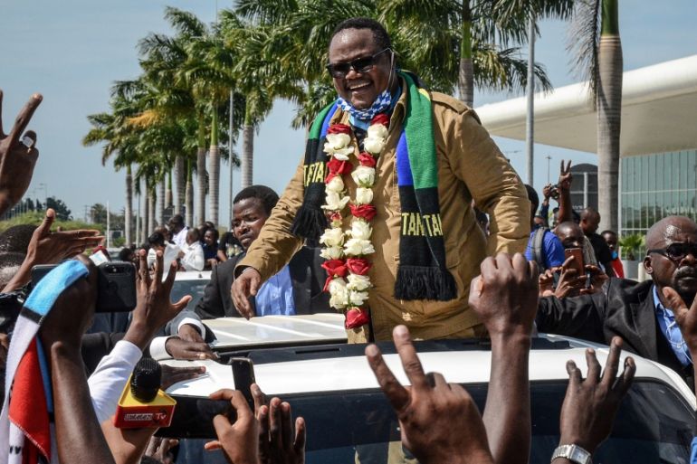 Tundu Lissu (C), Tanzania''s former MP with the Chadema main opposition party, who was shot 16 times in a 2017 attack, reacts to supporters as he returns after three years in exile to challenge Preside
