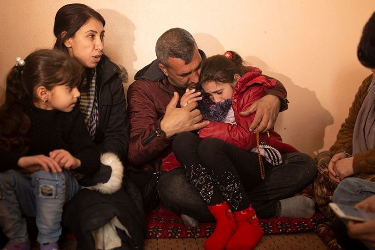 In this Feb. 12, 2020 photo, Malak Saad Dakhel, an 11 year-old Yazidi, is overwhelmed by journalists and well-wishers as her family tries to comfort her after her escape from Syria, in Sharia, Iraq. S