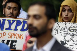 People hold signs while attending a rally to protest New York Police Department surveillance