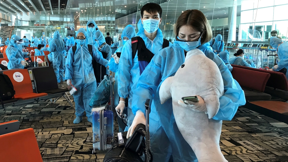 A Vietnamese woman carries a stuffed animal while boarding a repatriation flight from Singapore to Vietnam amid spread of the coronavirus disease (COVID-19) outbreak at Changi airport, Singapore