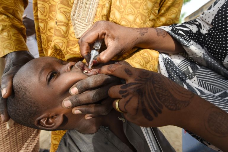 A Health worker administers a vaccine to a child during a vaccination campaign against polio at Hotoro-Kudu, Nassarawa district of Kano in northwest Nigeria. The World Health Organization (WHO) is to