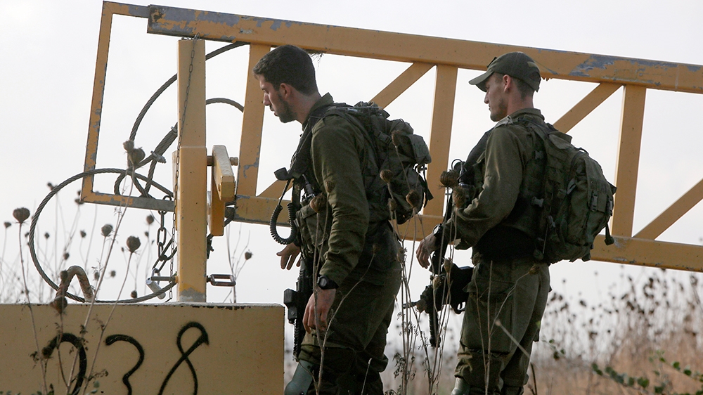 Israeli soldiers man a position on a road leading to the Syrian border, near the location where the army said it killed four men laying explosives at a security fence along the Israeli-occupied sector