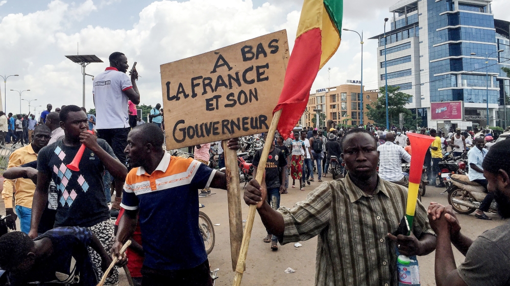 Opposition supporters react to the news of a possible mutiny of soldiers in the military base in Kati, outside the capital Bamako, at Independence Square in Bamako, Mali August 18, 2020. The sign read