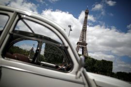 Car in front of Eiffel tower in Paris on sunny day