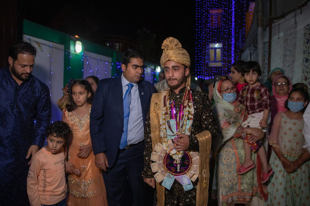 Relatives and neighbors walk along with Haseeb Mushtaq, a Kashmiri groom during his wedding ceremony on the outskirts of Srinagar, Indian controlled Kashmir, Monday, Sept. 14, 2020. The coronavirus pa