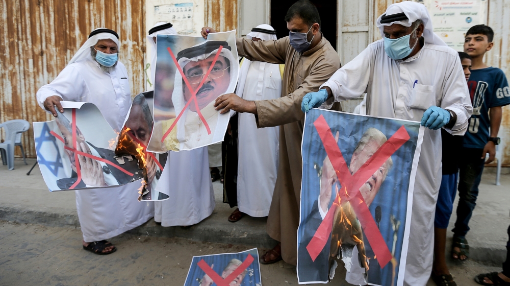 Palestinians burn pictures depicting U.S. President Donald Trump, Israeli Prime Minister Benjamin Netanyahu and Bahrain's King Hamad bin Isa Al Khalifa during a protest against Bahrain?s move to norma