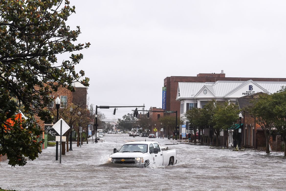 A city worker drives through the flooded street during Hurricane Sally in downtown Pensacola, Florida on September 16, 2020. - Hurricane Sally barrelled into the US Gulf Coast early Wednesday, with fo