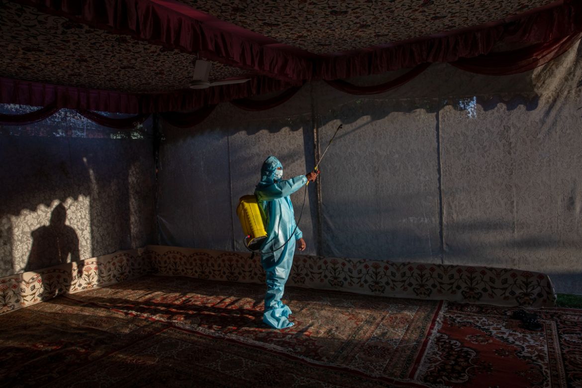 A Kashmir man in personal protective equipment sprays disinfectant to sanitize a wedding tent on the outskirts of Srinagar, Indian controlled Kashmir, Thursday, Sept. 17, 2020. The coronavirus pandemi
