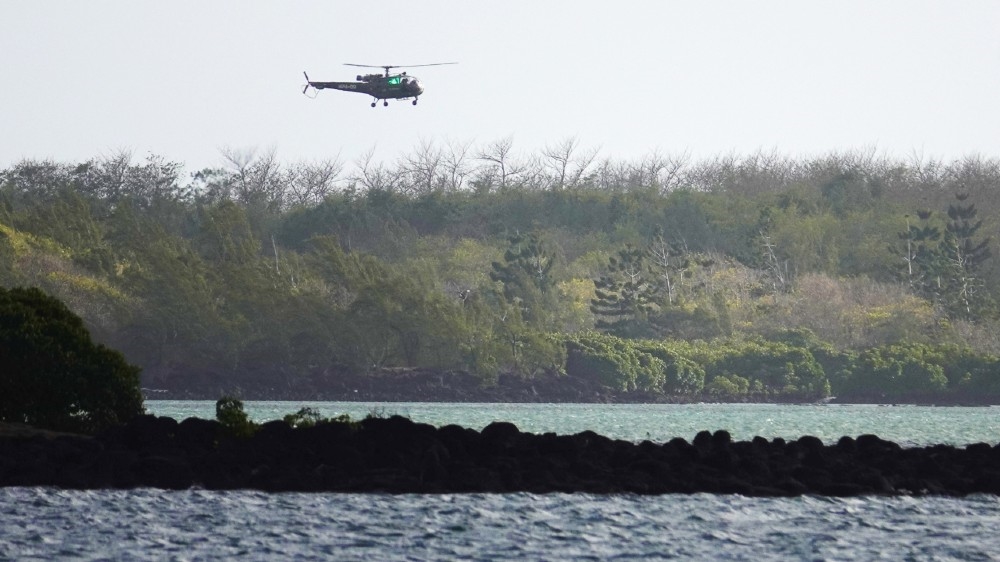A general view shows a coastguard search and rescue helicopter hovering near the scene where a tugboat involved in cleaning up an oil spill off from MV Wakashio, a Japanese bulk carrier