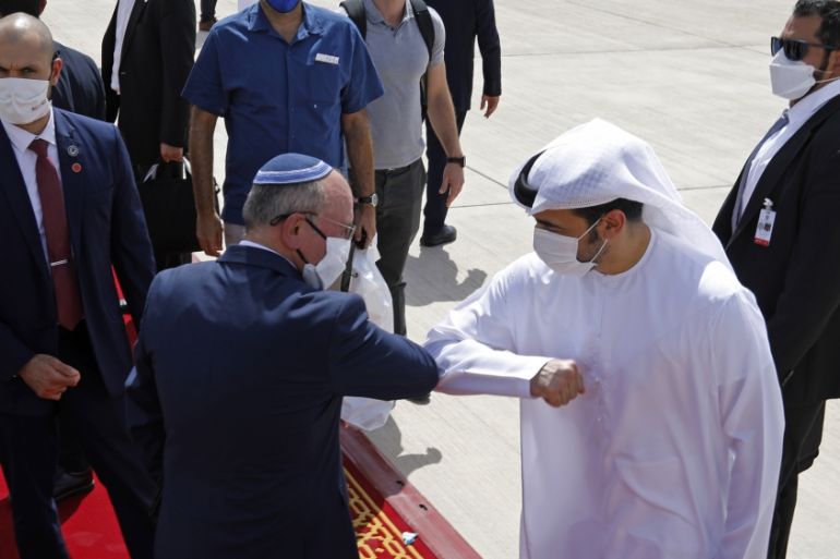 Israeli National Security Advisor Meir Ben-Shabbat, center left, elbow bumps with an Emirati