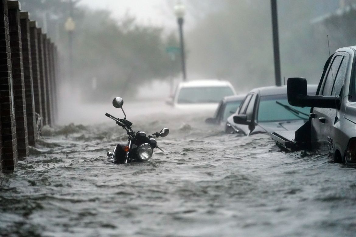 Cars and a motorcycle are underwater as water floods a street, Wednesday, Sept. 16, 2020, in Pensacola, Fla. Hurricane Sally made landfall Wednesday near Gulf Shores, Alabama, as a Category 2 storm, p