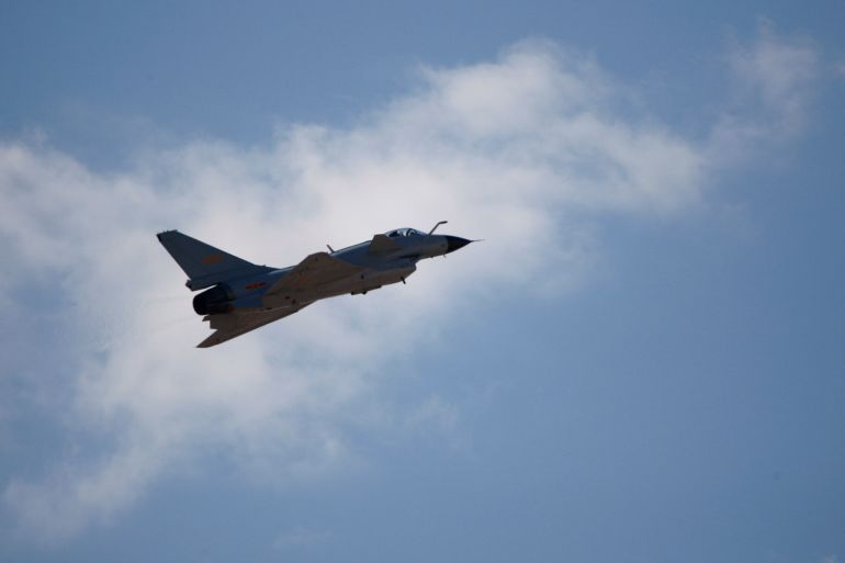 A J-10 fighter jet silhouetted against a cloud