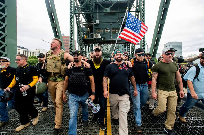 members of the Proud Boys and other right-wing demonstrators march across the Hawthorne Bridge during a rally in Portland, Ore.