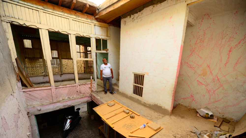 Aysser Al Ameri stands in a house he recently purchased in Baghdad’s old Shewake neighborhood. It features old Baghdadi architectural features, including an inner court yard and wooden balcony called 