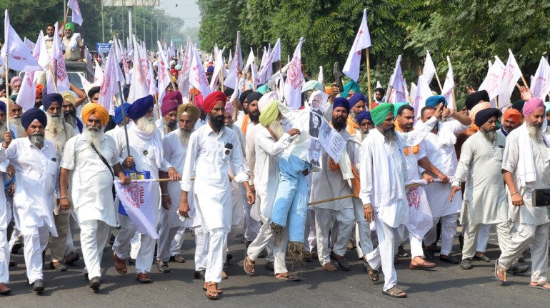 Farmers shout slogans as they march to burn an effigy of India''s Prime Minister Narendra Modi and Union Agriculture Minister Narendra Singh Tomar, following the passing of agriculture bills in the Lok
