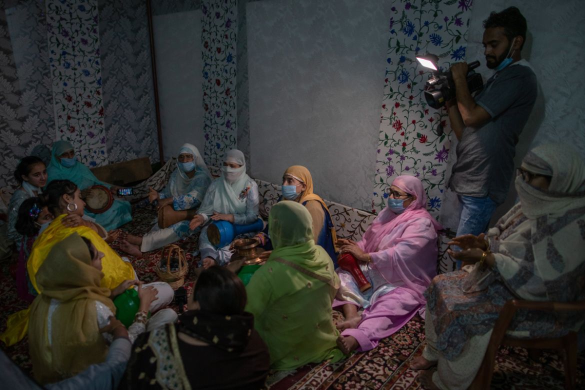 Relatives and neighbors of Kashmiri groom Haseeb Mushtaq, sing during henna ceremony of his wedding in Srinagar, Indian controlled Kashmir, Sunday, Sept. 13, 2020. The coronavirus pandemic has changed